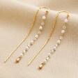 Thread Through Crystal and Pearl Chain Earrings in Gold on Beige Fabric