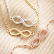 Infinity Charm Bracelets in Silver Gold and Rose Gold on Beige Fabric