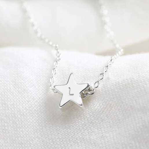Close up of silver star bead necklace with L hand stamped in clean