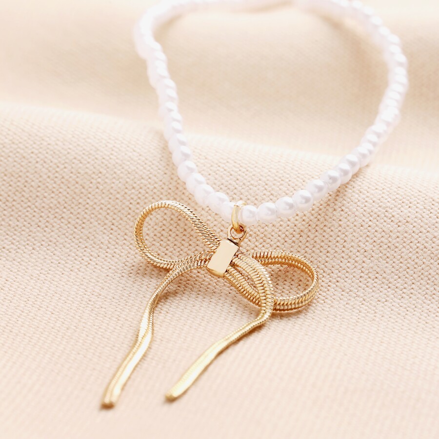 A Sleek Pearl Necklace Adorned with a Striking Bow Pendant is a Great way to Incorporate a Classic Bridal Feature With A trend Led Detail