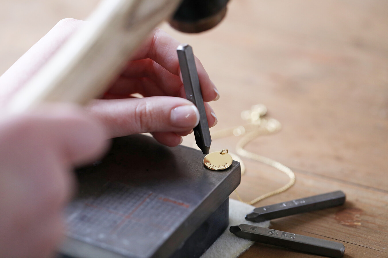 Our In-House Team Hand Stamping a Personalised Pendant Necklace