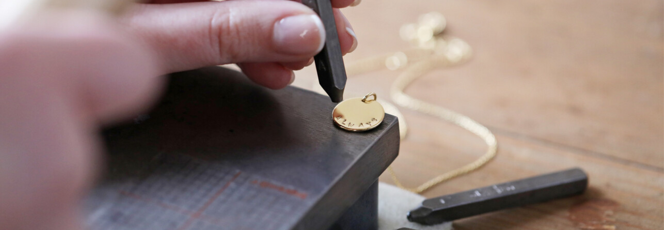 Our In-House Team Hand Stamping a Personalised Pendant Necklace