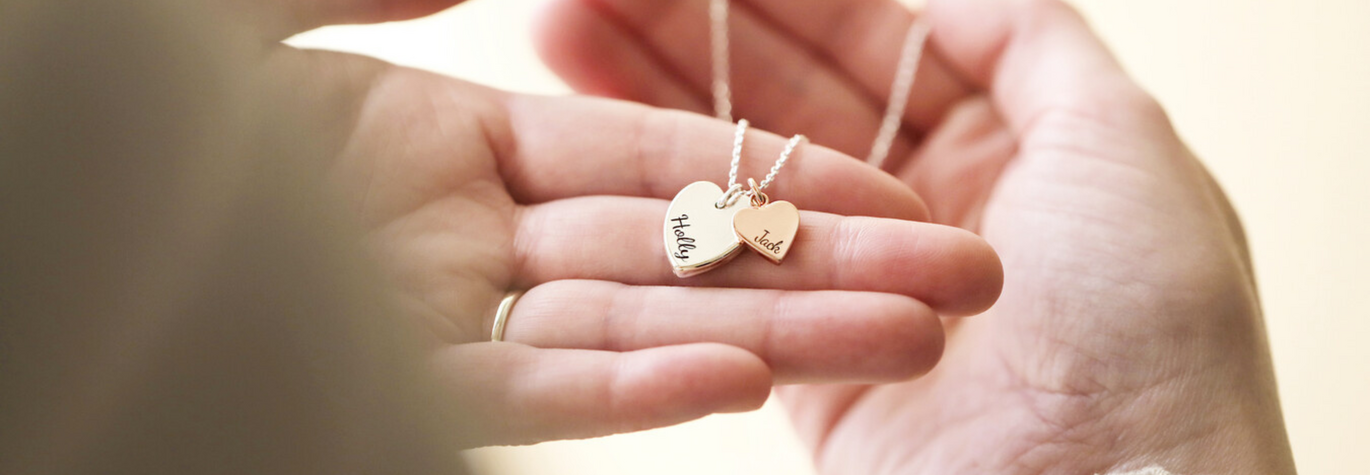 Model Holding Personalised Double Heart Charm Necklace