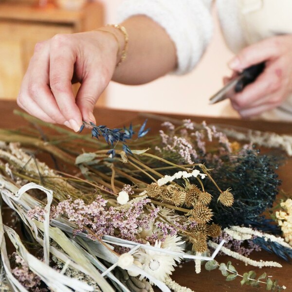 Model adjusting flowers in packaging of luxury midwinter dried flower bouquet