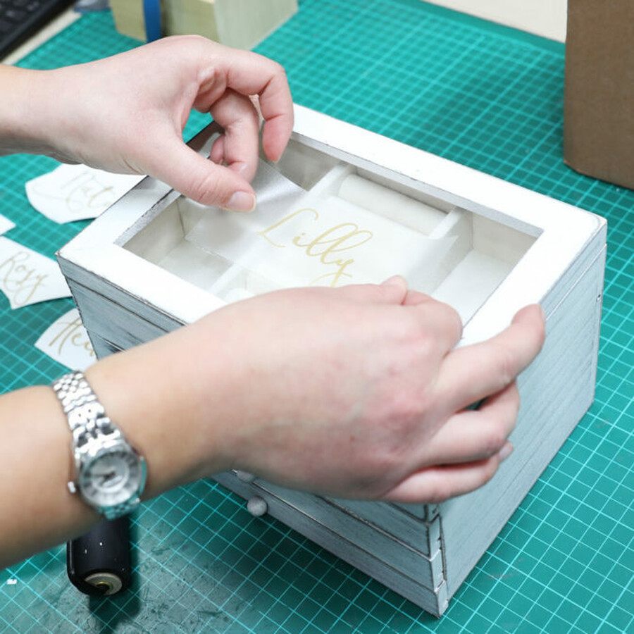 worker personalising jewellery box with vinyl