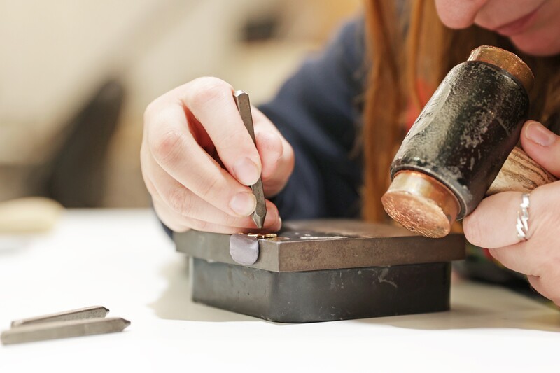 person hand stamping a ring 