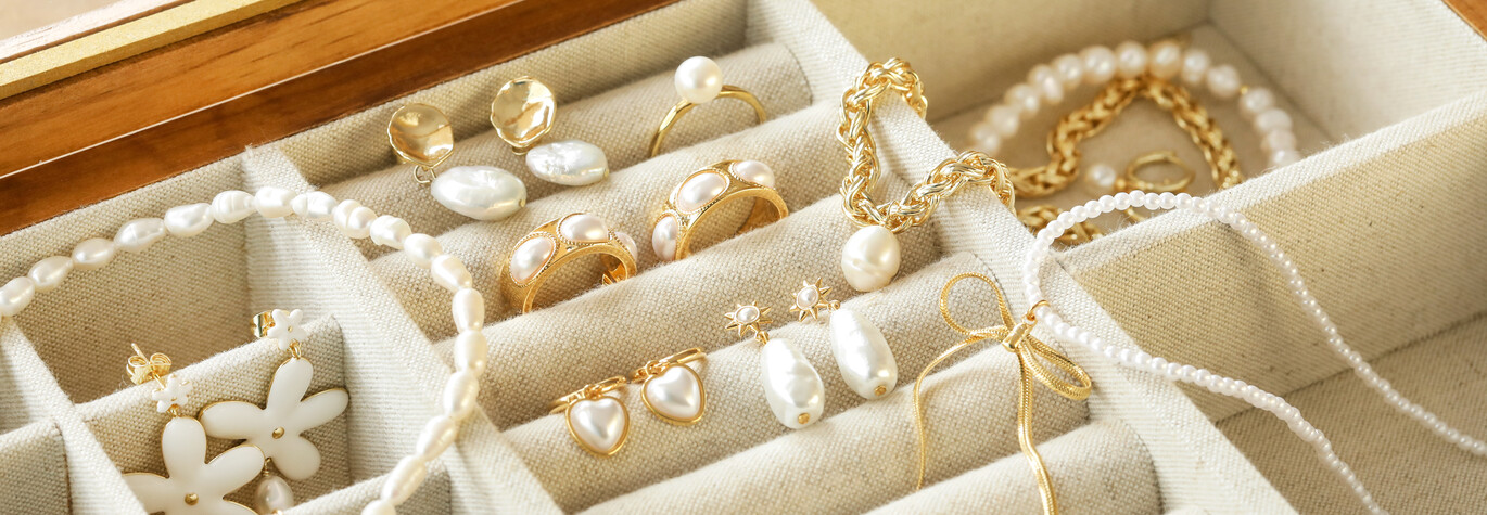 Pearl jewellery arranged on top of open jewellery box