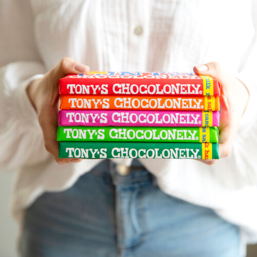 A model holding 5 colourful bars of Tony's Chocolonely