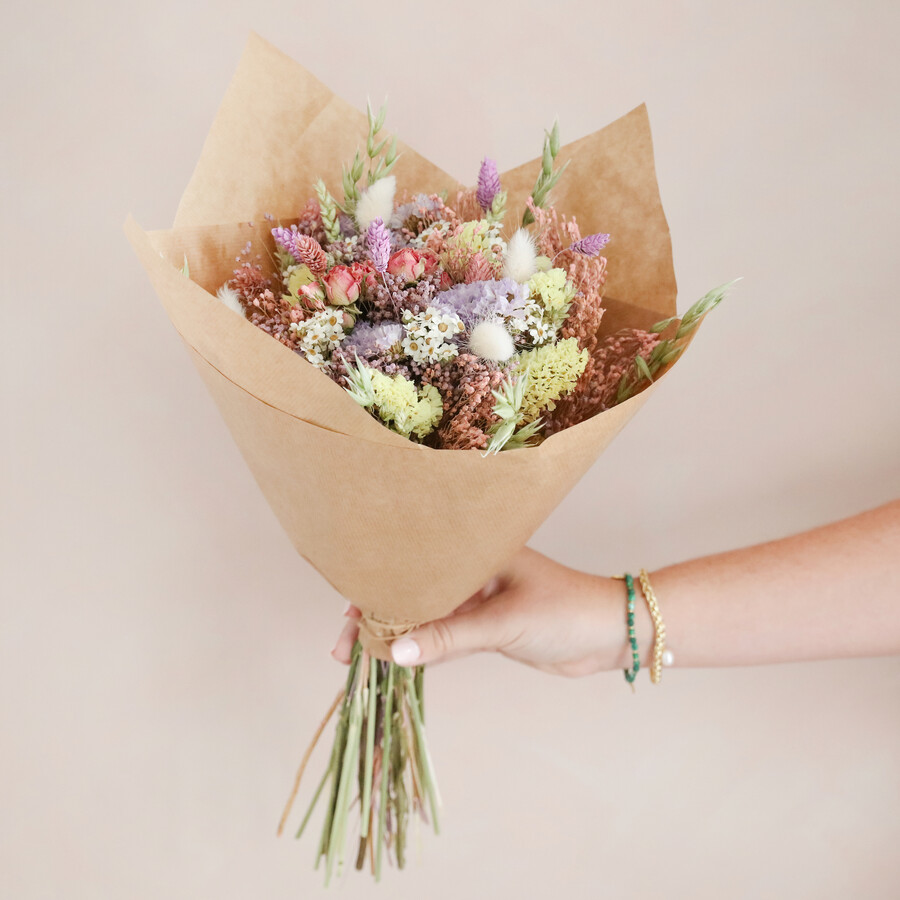 A Luxurious Dried Flower Arrangement in Pink and Pastel Tones Wrapped in Brown Paper