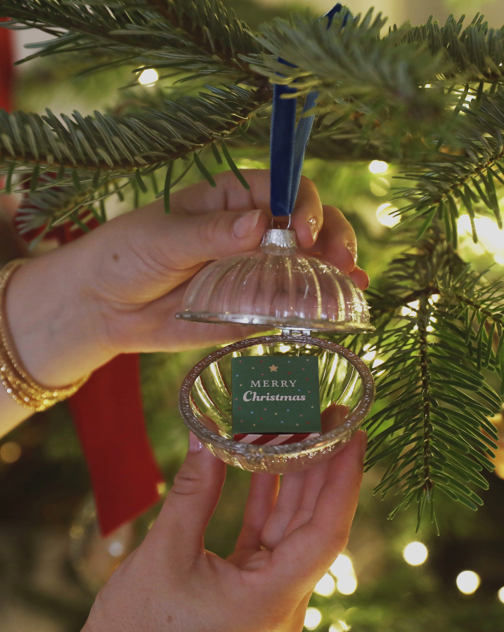 Model holding Christmas tree token inside Ribbed Clear Glass Secret Opening Bauble 