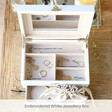 inside of white embroidered jewellery box