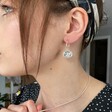 Ladies' Wax Seal Bee Charm Hoop Earrings in Silver on Model