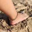 model wearing Oversized Flat Curb Chain Anklet with foot in sand on the beach