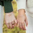 Two Models Wearing Personalised Heart Initial and Birthstone Bracelet and Holding Pinkies