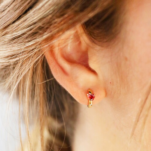 Female Model Wearing Crystal Red Heart Huggie Hoops in Gold