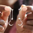 Model Holding Crystal Star and Moon Double Drop Earrings in Silver