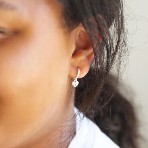 Polished Heart Huggie Hoop Earrings in Silver on Model
