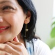 Female Model Wearing Thread Through Mismatched Heart Earrings in Gold