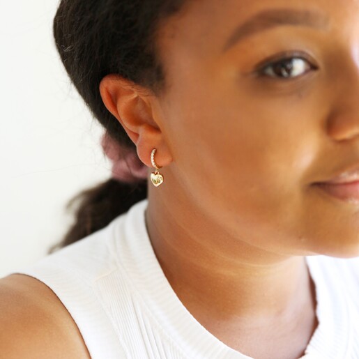 Model Wears Polished Heart and Crystal Huggie Hoop Earrings in Gold