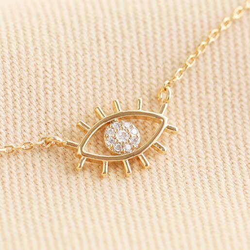 Close Up of Clear Crystal Eye Charm Pendant on Necklace in Gold