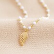 Close Up of Lisa Angel Enamel White Pearl Necklace With Wing Charm in Gold