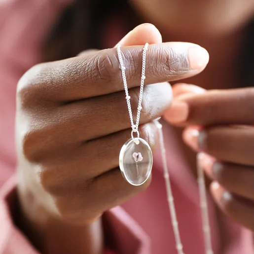 Model Holding Lisa Angel Pressed Birth Flower Pendant Necklace in Silver