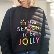 Blonde Model Wearing Tis The Season to be Jolly Sweatshirt in Black