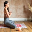 Model in Sitting Yoga Pose with Persian Rug Style Mat