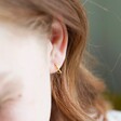 Close Up of Ladies' Lisa Angel Mini Gold Sterling Silver Heart Hoop Earrings On Model