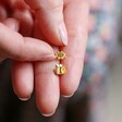 Model Holding Mismatched Enamel Bee and Sunflower Stud Earrings in Gold