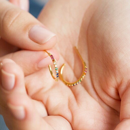Model Holding Lisa Angel Rainbow Crystal Hoop Earrings in Gold