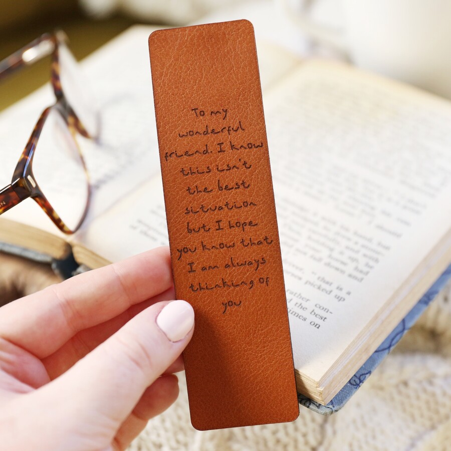 Personalised Meaningful Message Leather Bookmark held by model in front of open book