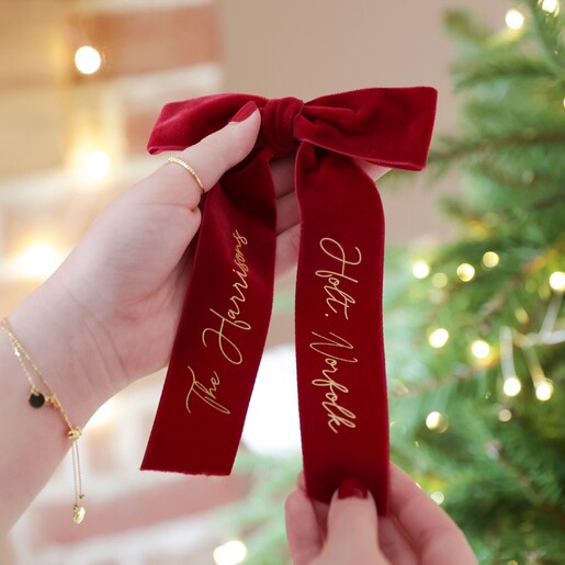 Model Holding Red Personalised Velvet Bow Hanging Decoration