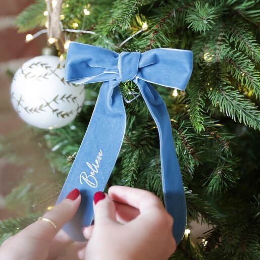 Model Holding Personalised Blue Velvet Bow Hanging Decoration