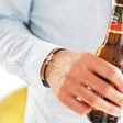 Model Wears Lisa Angel Men's Personalised Leather Bracelet with Disc Clasp Holding Beer