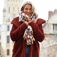 Female model wearing Lisa Angel Blue and Yellow Check Blanket Scarf and looking to camera smiling