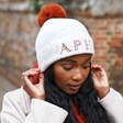 Model Wearing Personalised Natural Marled Winter Hat with Terracotta Pom Pom