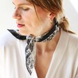 Model Wearing Black and White Paisley Scarf wrapped around gift