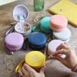 Range of Colourful Personalised Birthday Mini Round Travel Jewellery Cases on Wooden Table