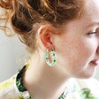 Model Wearing Ladies' Dried Flower Resin Hoop Earrings in Green