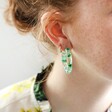 Model Wearing Unique Dried Flower Resin Hoop Earrings in Green
