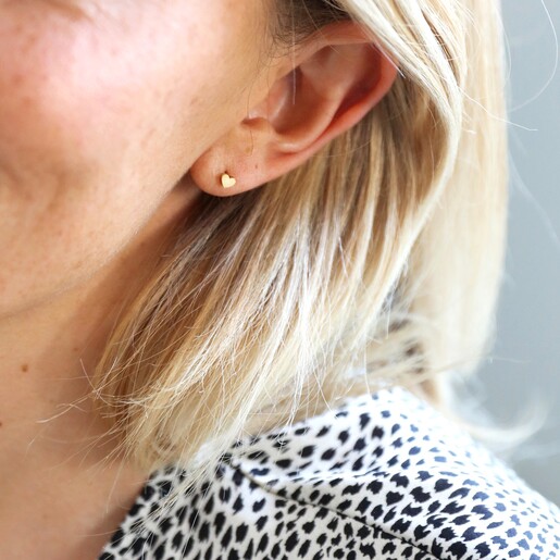 Model Wearing Tiny Stainless Steel Heart Stud Earrings in Gold