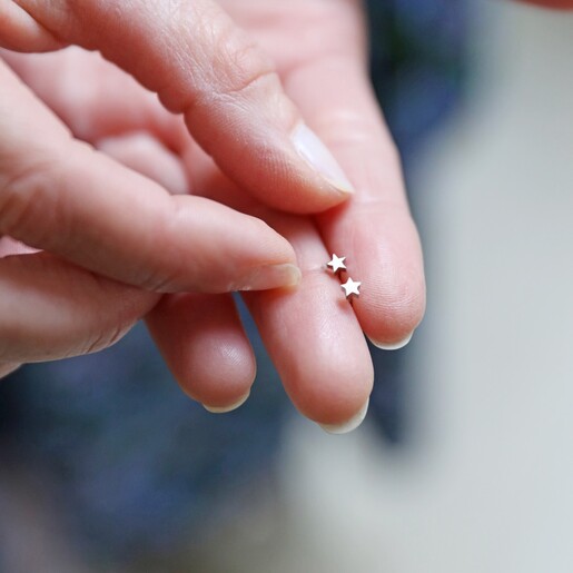 Model Holding Tiny Stainless Steel Star Stud Earrings