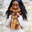 Model Wears Lisa Angel Personalised Embroidered Check Blanket Scarf in Light Brown