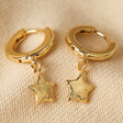 Antiqued Effect Star Charm Huggie Hoop Earrings in Gold on Beige Fabric