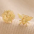 Mismatched Daisy and Bee Stud Earrings in Gold on Beige Fabric