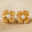 Small Flower and Pearl Stud Earrings in Gold on Beige Fabric
