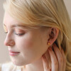 Blonde Model Wearing Small Flower and Pearl Stud Earrings in Gold