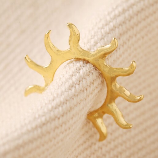 Sun Ear Cuff in Gold Held Up by Beige Coloured Fabric
