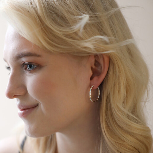 Earrings on Model Model Wearing Textured Hoop Earrings in Silver Head Turned to Side
